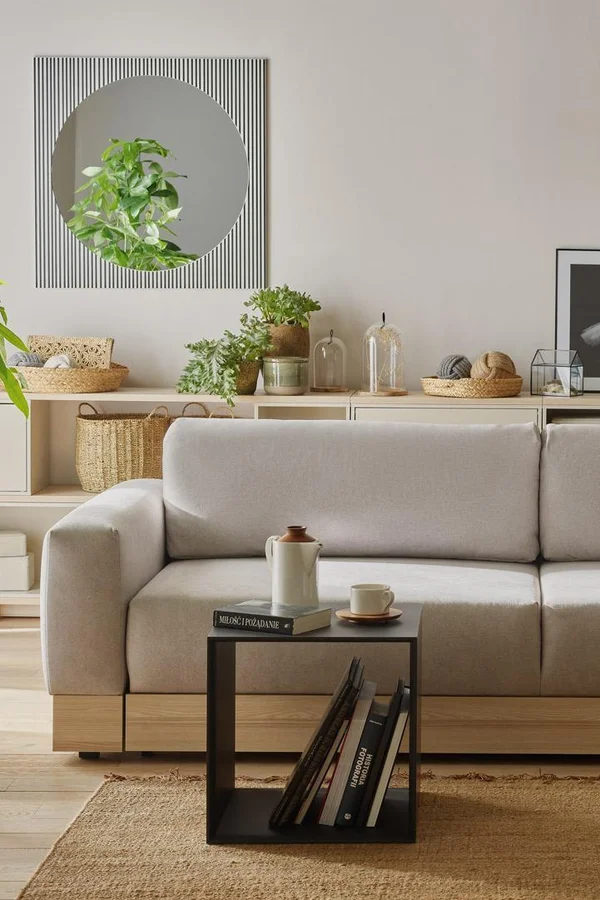 Nowo urządzony Salon z sofą i stolikiem kawowym z książkami.